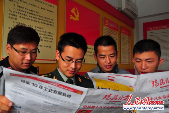 图为边防民警和大学生村官学习十八大精神