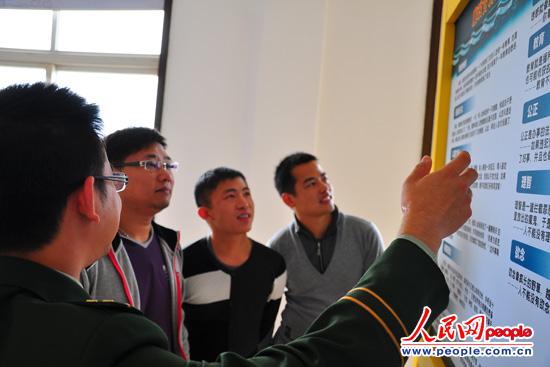图为边防民警为大学生村官讲解边防工作性质