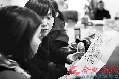 两名研究生正在研究磨店地区图，第二批7名研究生村官通过抓阄被安排到各个社区