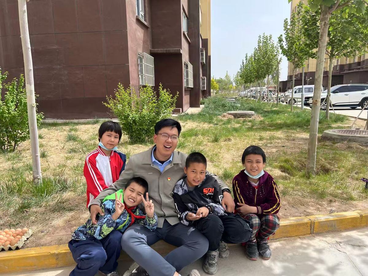 张开弓（中）在为孩子补习功课的休息间隙。（乌尊村村委会供图）.jpg